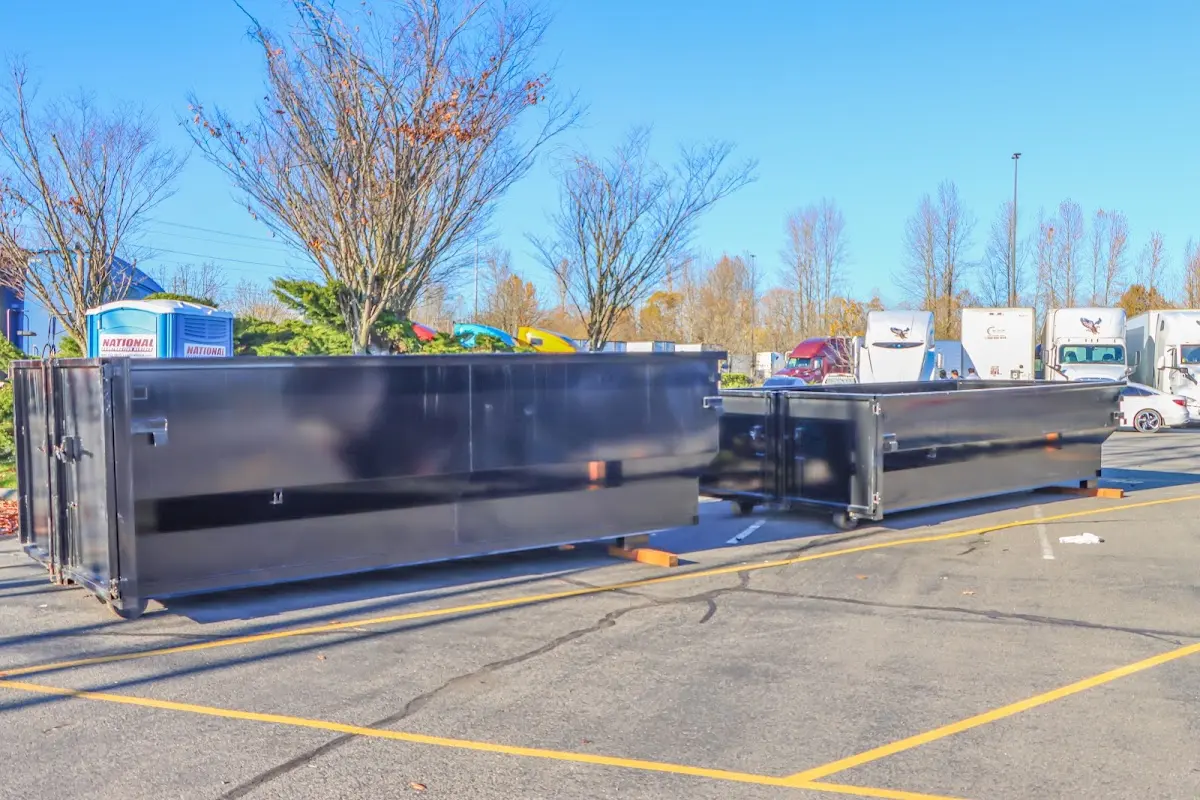 Professional dumpster rental service with roll-off container on residential driveway in Providence